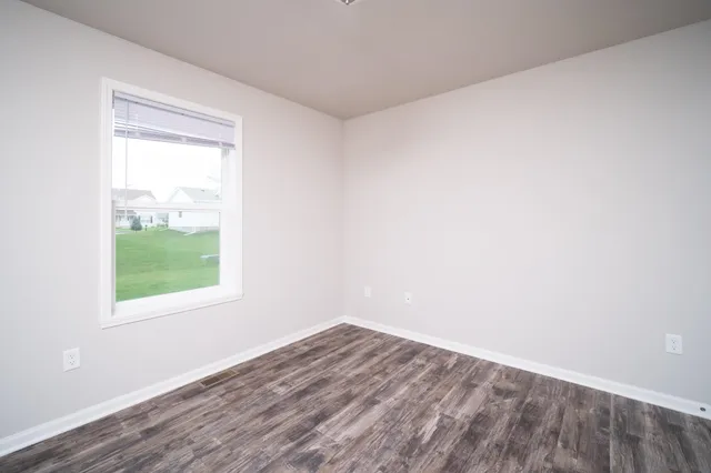 a view of a big room with wooden floor and windows