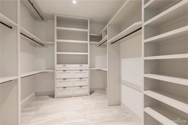 a view of walk in closet with empty racks