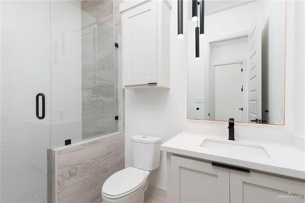 a bathroom with a sink a toilet and shower