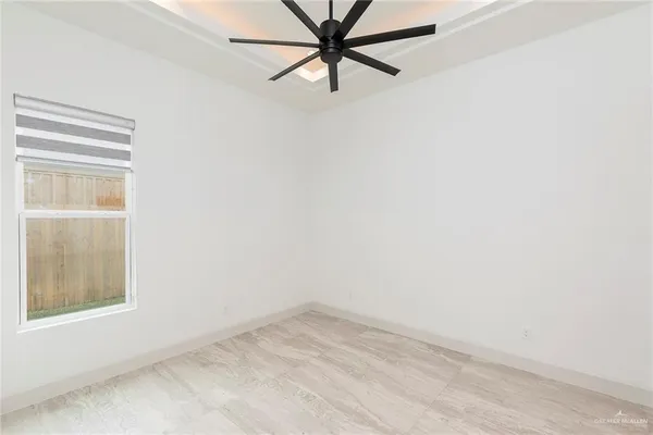 an empty room with a window and a fan