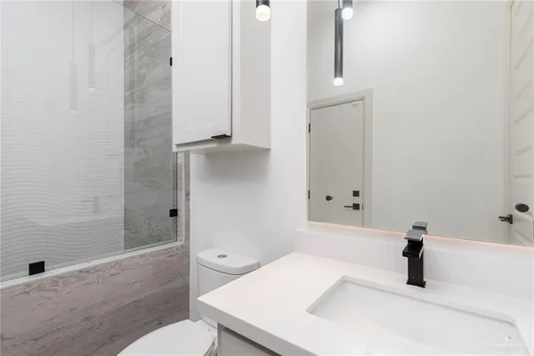a bathroom with a sink a toilet and shower