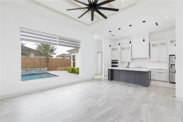 a large white kitchen with a large window cabinets and stainless steel appliances