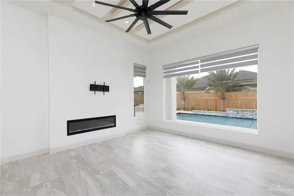 an empty room with windows and fan