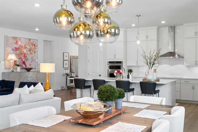 a living room with furniture kitchen view and a chandelier