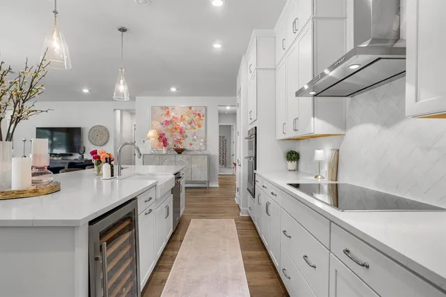 a view of living room kitchen with furniture wooden floor and windows