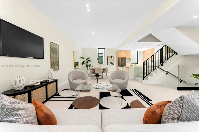 a living room with furniture a large window and a potted plant