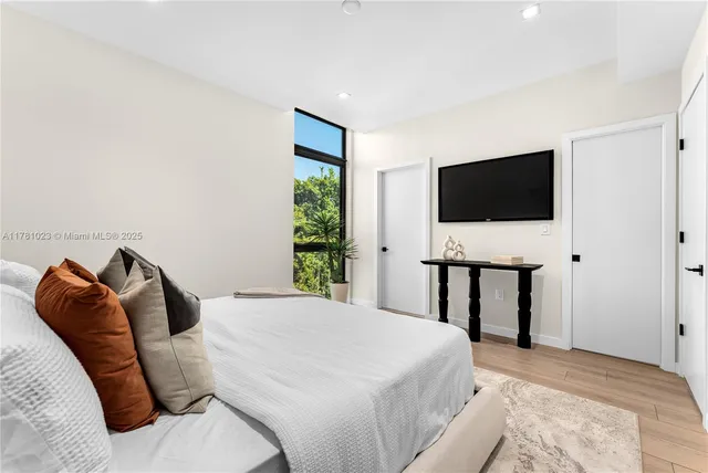 a bathroom with a sink a mirror and a potted plant