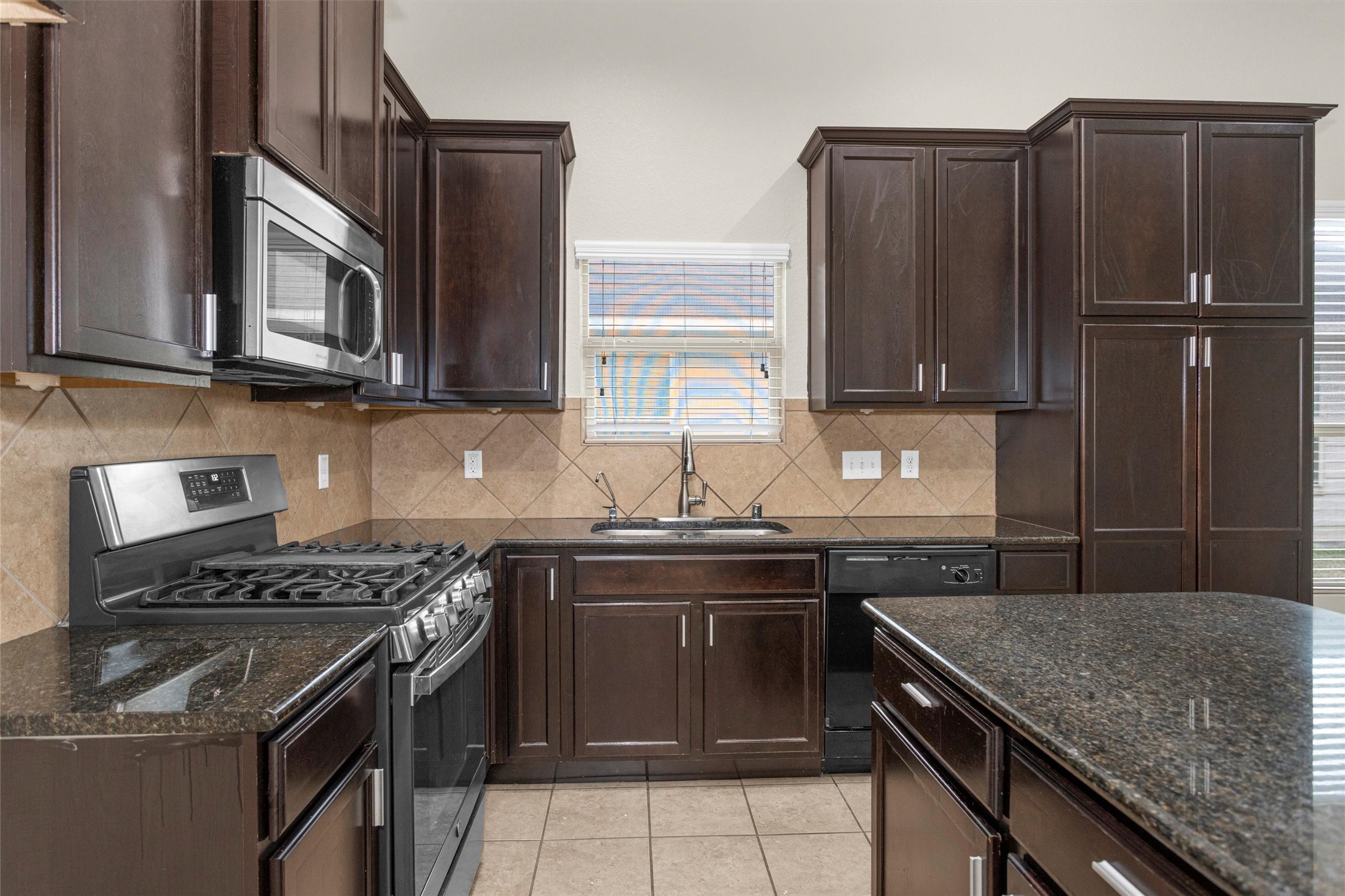 21419 Fossil Trails Drive Spring, TX 77388 - Photo 13 of 42 a kitchen with stainless steel appliances granite countertop a stove a sink and a microwave