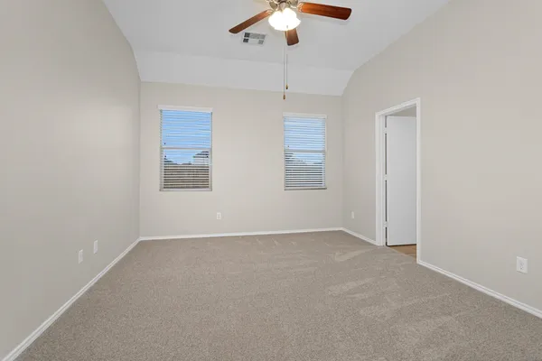 an empty room with chandelier fan