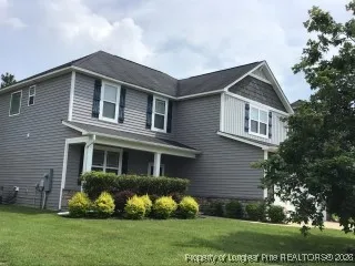 a front view of a house with a yard and plants