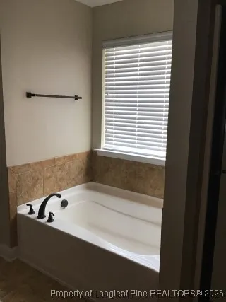 a bathroom with a bathtub and a window
