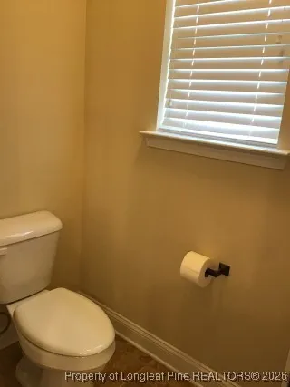 a bathroom with a toilet and a window