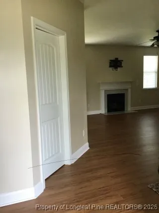 a view of a livingroom with wooden floor and a fireplace