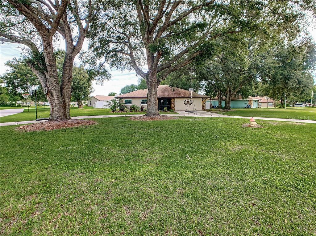 Large mature oaks and circular driveway frame an inviting home.