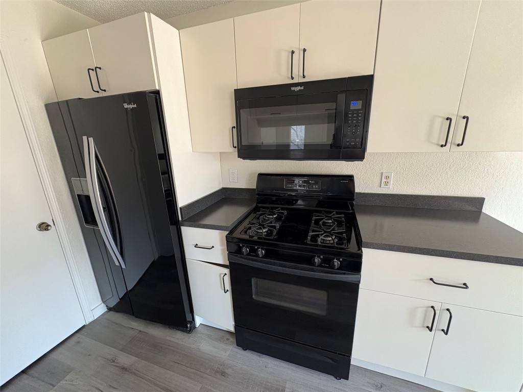 1128 Orchard Park Circle Pflugerville, TX 78660 - Photo 11 of 14 a kitchen with stainless steel appliances wooden cabinets and a stove