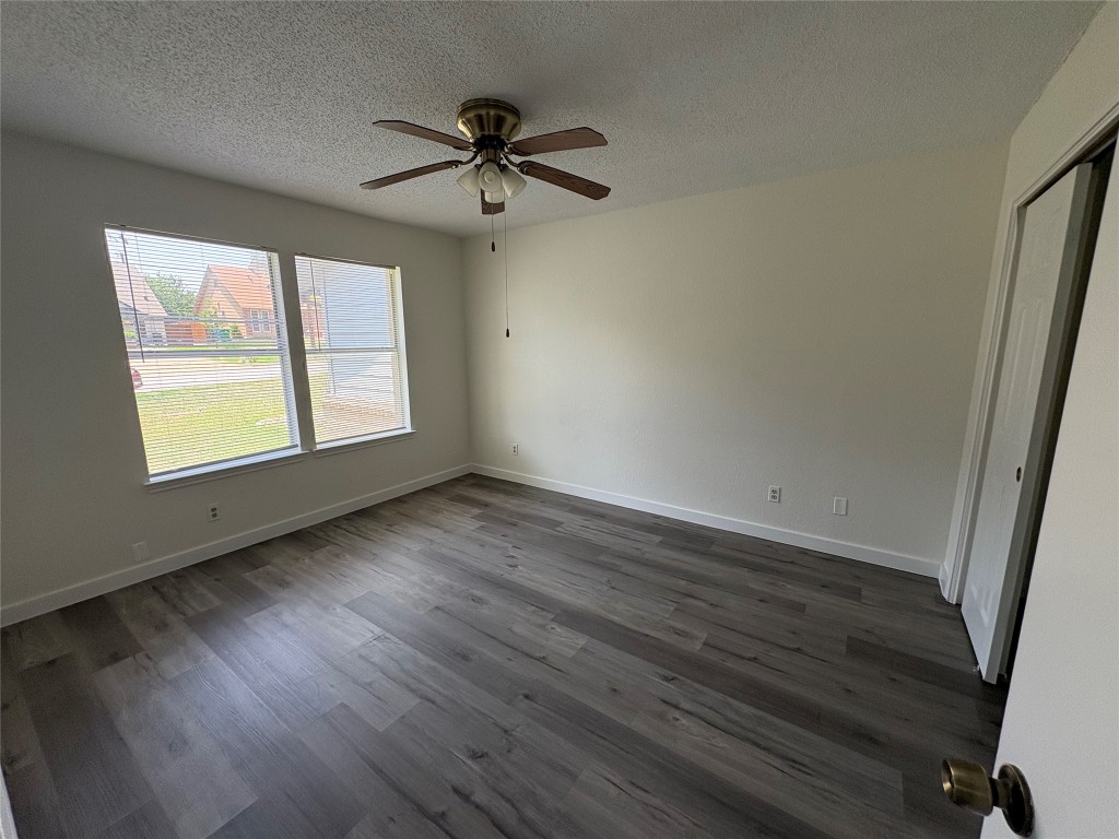 1128 Orchard Park Circle Pflugerville, TX 78660 - Photo 13 of 14 an empty room with wooden floor fan and windows