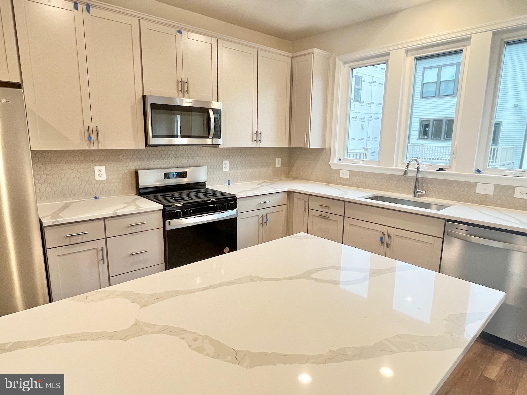236 Mainstream Drive Laurel, MD 20724 - Photo 11 of 52 a kitchen with a sink a stove and cabinets
