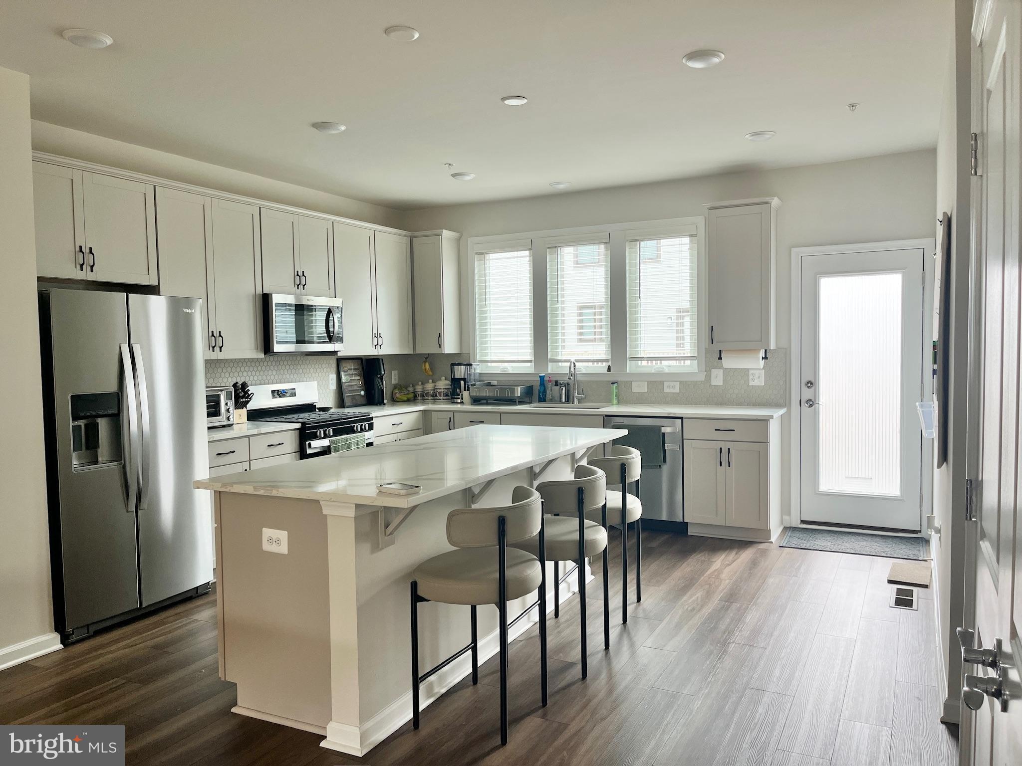 236 Mainstream Drive Laurel, MD 20724 - Photo 4 of 52 a kitchen with stainless steel appliances granite countertop a refrigerator a sink dishwasher a stove and white countertops with wooden floor