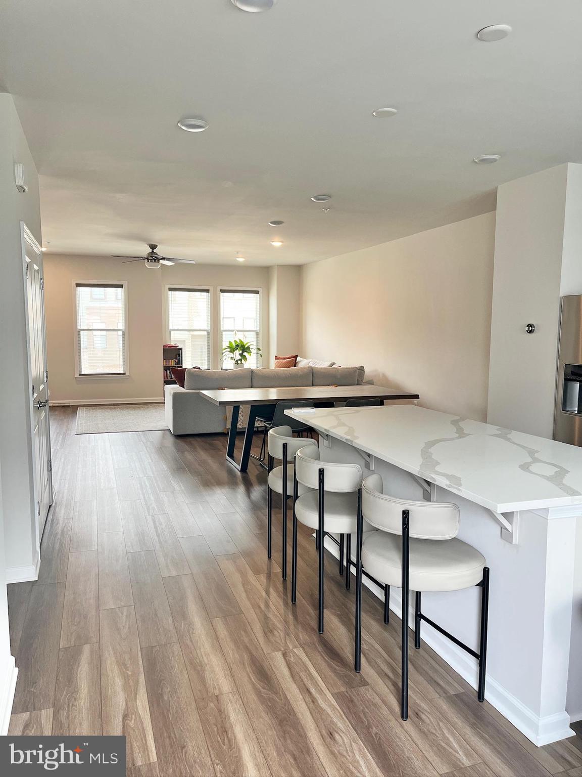 236 Mainstream Drive Laurel, MD 20724 - Photo 6 of 52 a living room with a table chairs wooden floors and a view of kitchen