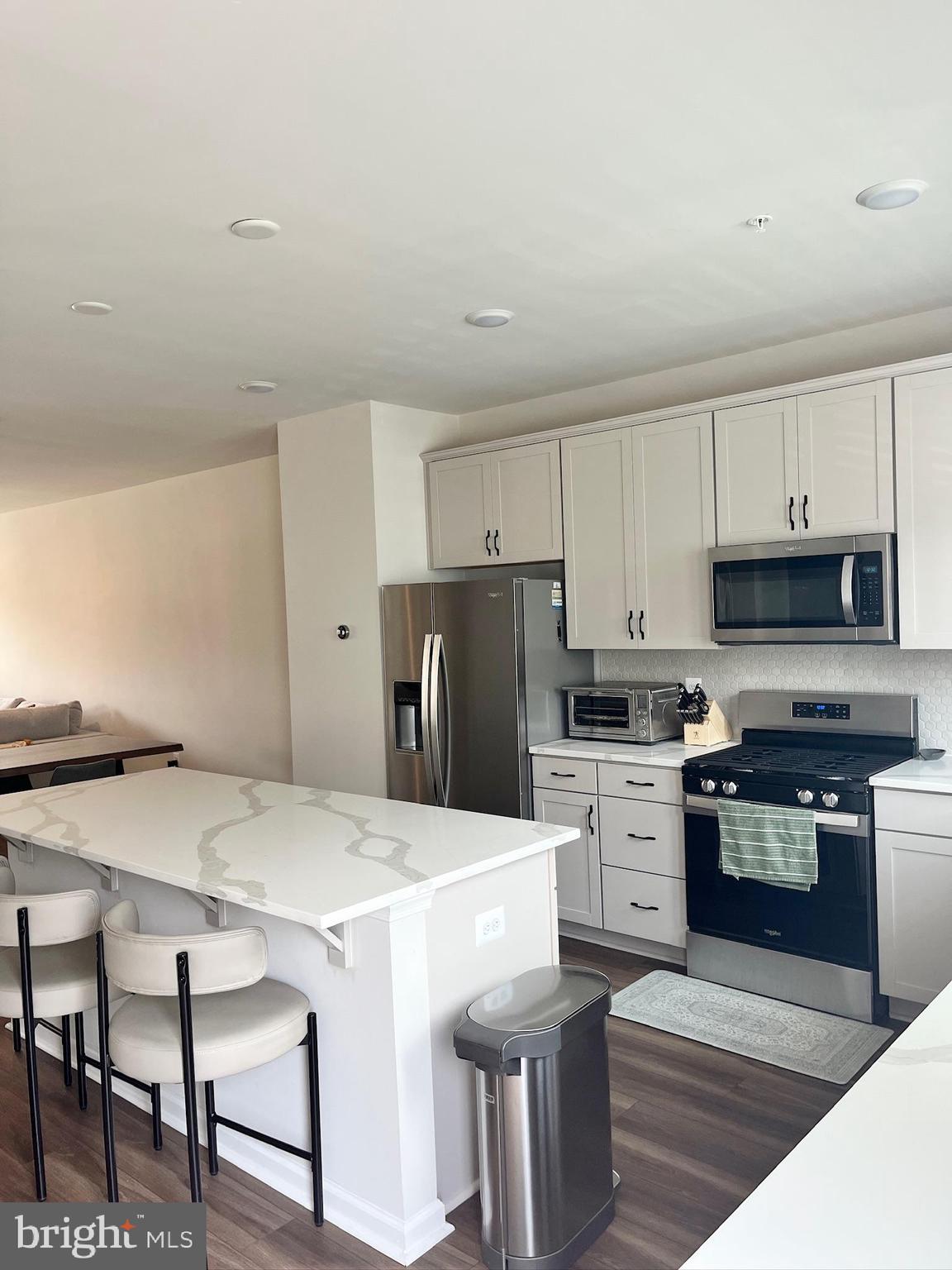 236 Mainstream Drive Laurel, MD 20724 - Photo 8 of 52 a kitchen with stainless steel appliances white cabinets and wooden floor