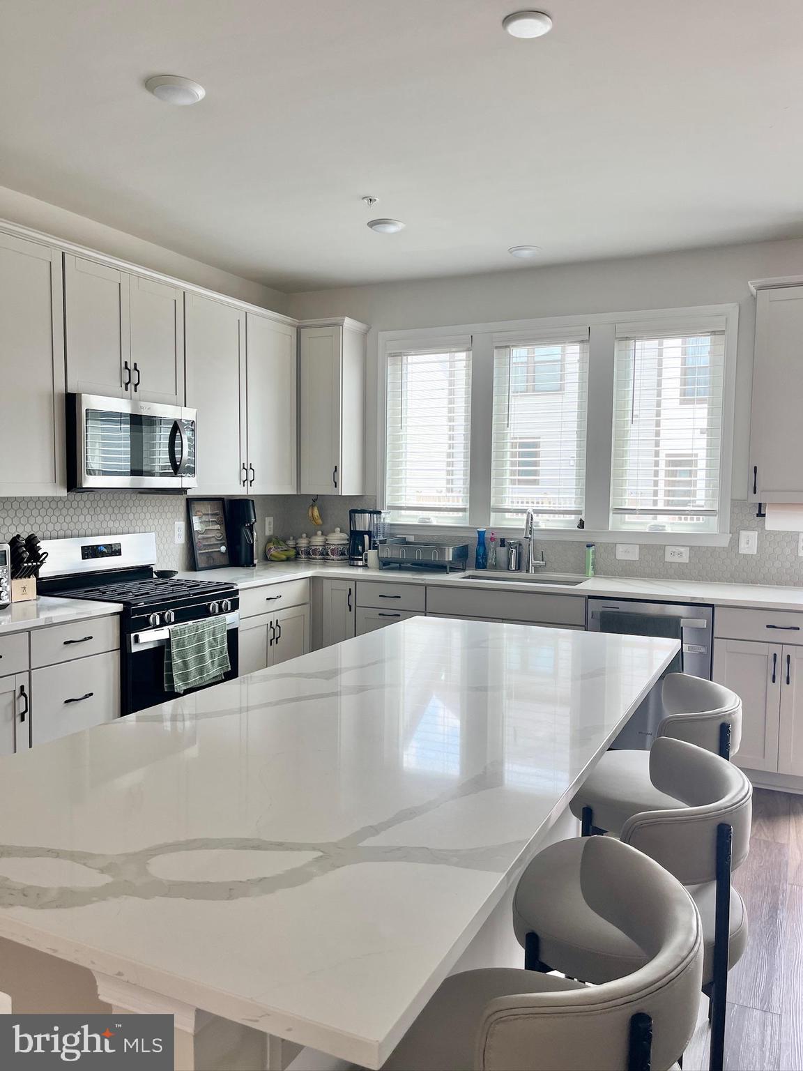 236 Mainstream Drive Laurel, MD 20724 - Photo 10 of 52 a large kitchen with granite countertop lots of white cabinets a sink and a stove