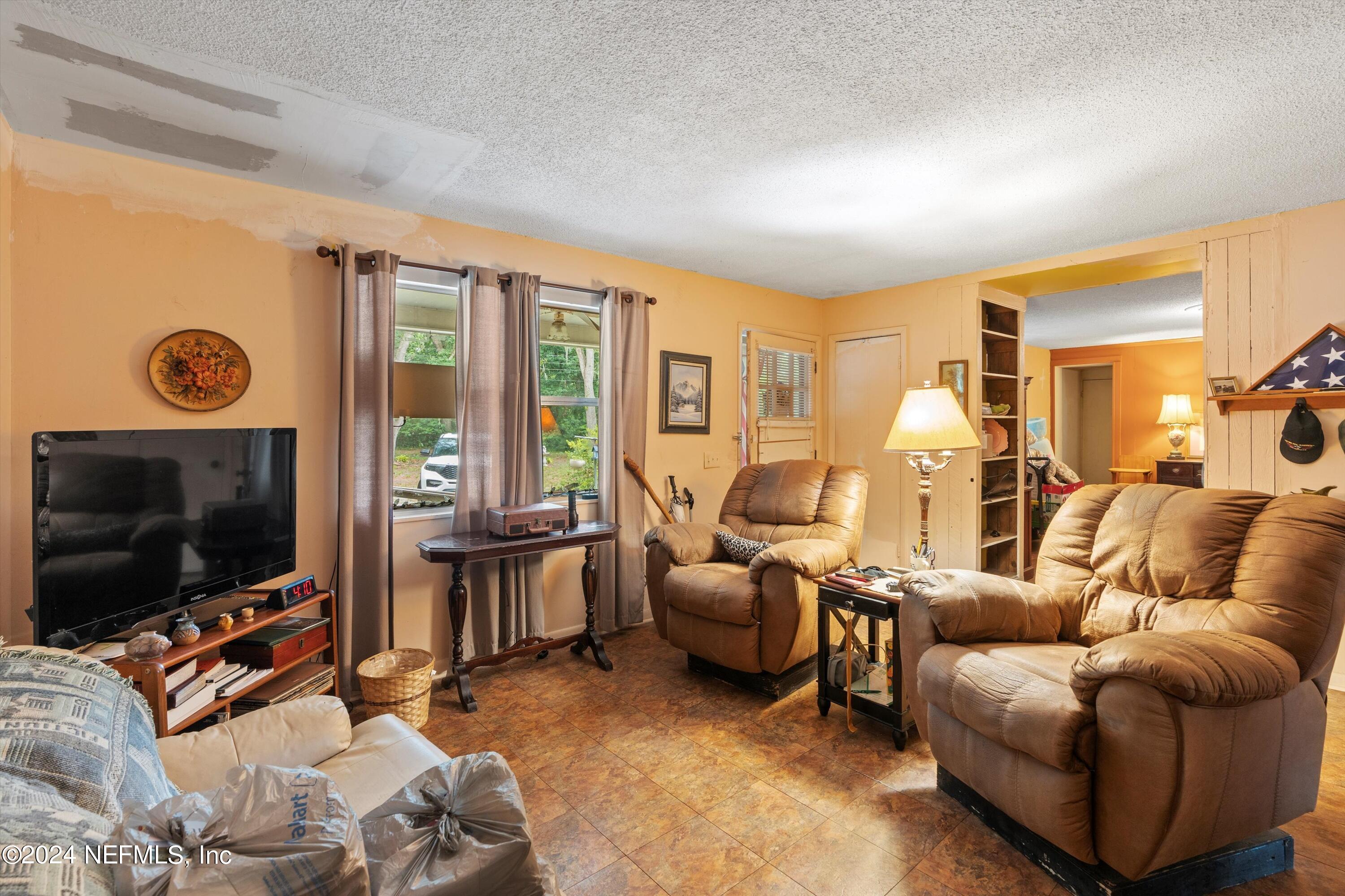 1128 Taylor Road Jacksonville, FL 32234 - Photo 5 of 26 a living room with furniture and a flat screen tv
