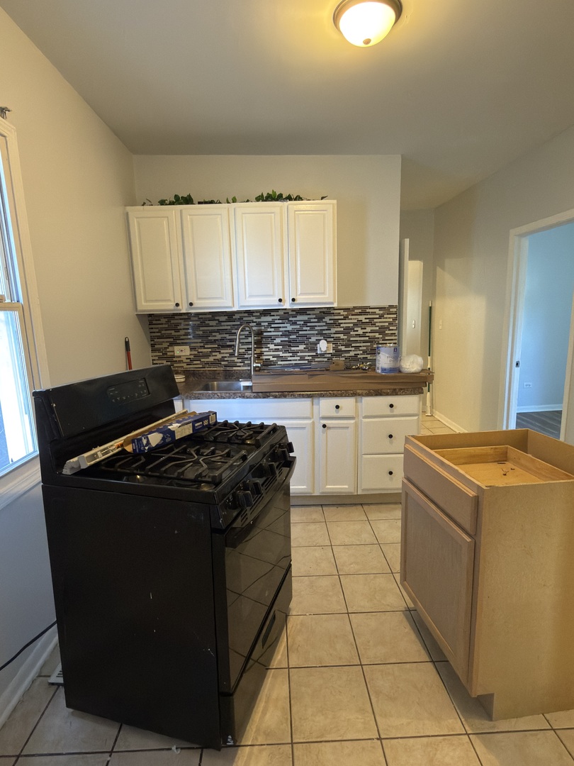2020 West 69th Place Chicago, IL 60636 - Photo 9 of 12 a kitchen with a stove a sink and a refrigerator