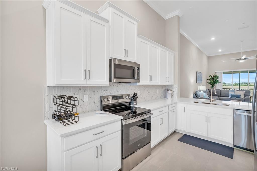 11811 Venetian Lagoon Drive, Unit 202 Fort Myers, FL 33913 - Photo 13 of 50 a kitchen with white cabinets and white appliances