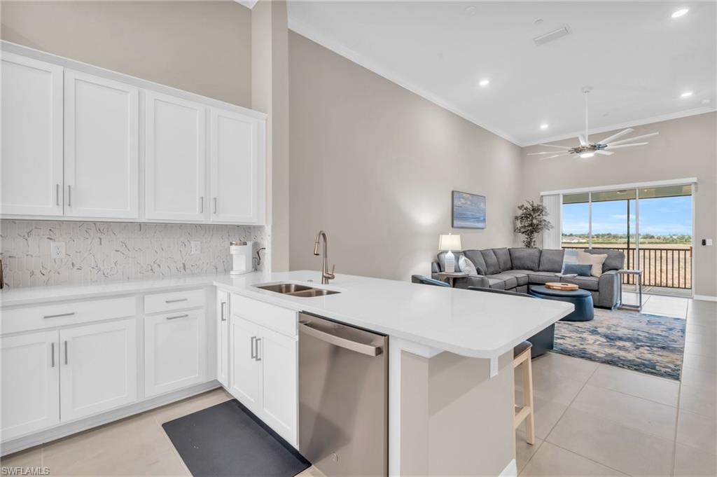 11811 Venetian Lagoon Drive, Unit 202 Fort Myers, FL 33913 - Photo 15 of 50 a kitchen with sink a stove and cabinets