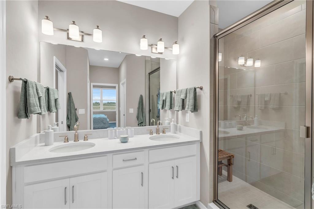 11811 Venetian Lagoon Drive, Unit 202 Fort Myers, FL 33913 - Photo 22 of 50 a bathroom with a double vanity sink mirror and shower