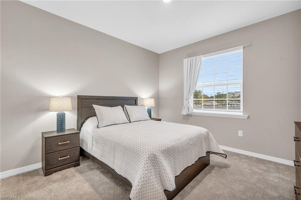 11811 Venetian Lagoon Drive, Unit 202 Fort Myers, FL 33913 - Photo 24 of 50 a large bed sitting in a bedroom next to a window