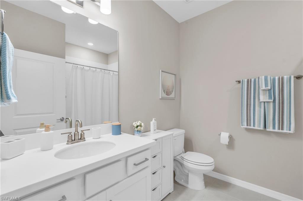 11811 Venetian Lagoon Drive, Unit 202 Fort Myers, FL 33913 - Photo 26 of 50 a bathroom with a toilet a sink a mirror and vanity