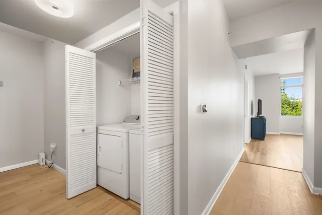 a view of a hallway with wooden floor and a bathroom