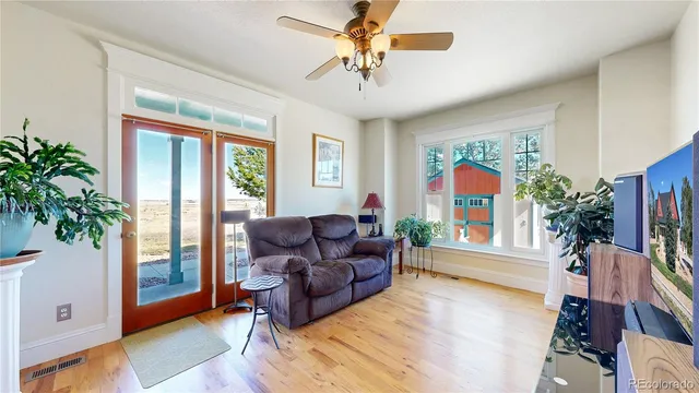 a living room with furniture and a large window with wooden floor