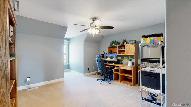 a view of a workspace with furniture and a window