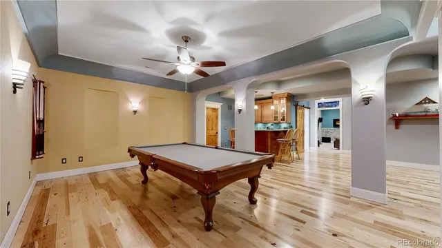 a room with wooden floor and pool table