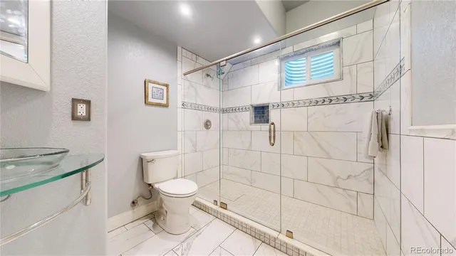 a bathroom with a granite countertop bathtub and a toilet