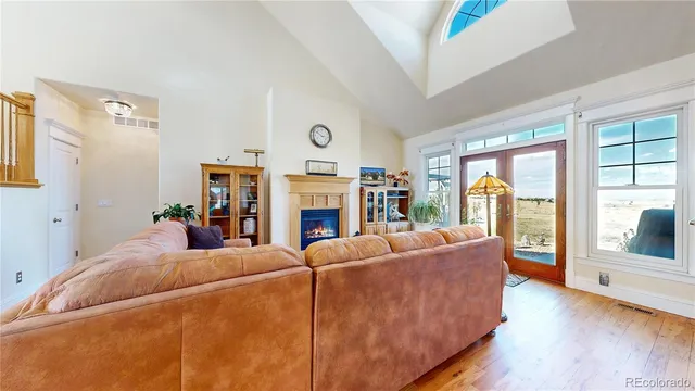 a living room with furniture a large window and a fireplace
