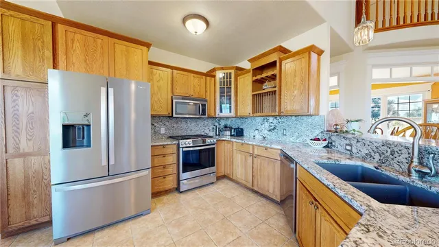 a kitchen with stainless steel appliances granite countertop a refrigerator stove and sink