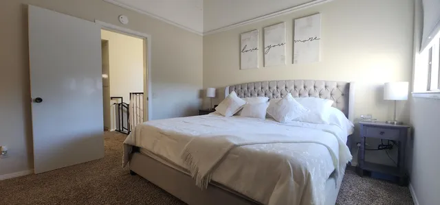 a living room with flat screen tv on the dresser and a bookshelf