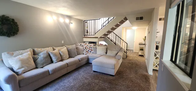 a living room with furniture and a stairs