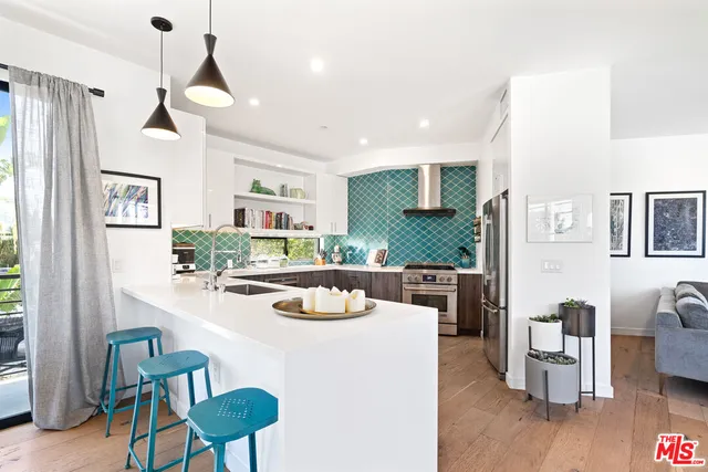 a kitchen with a dining table chairs and refrigerator