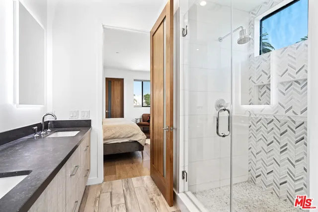 a en suite bathroom with a granite countertop sink and a mirror