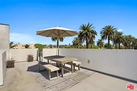 a patio with a table and chairs under an umbrella