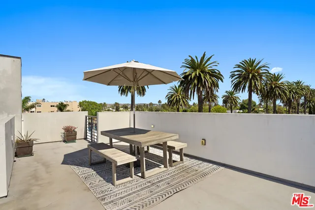 a patio with a table and chairs under an umbrella