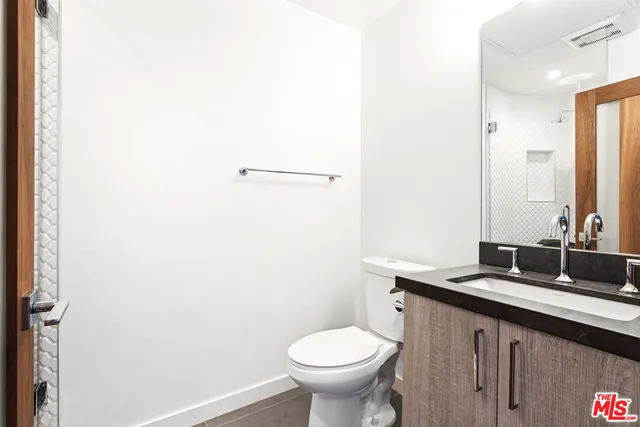 a bathroom with a double vanity sink toilet and a tub