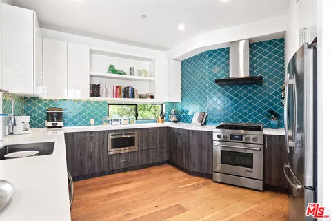 a kitchen with stainless steel appliances granite countertop a stove a sink and a refrigerator