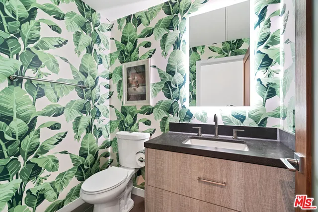 a bathroom with a granite countertop sink and a toilet