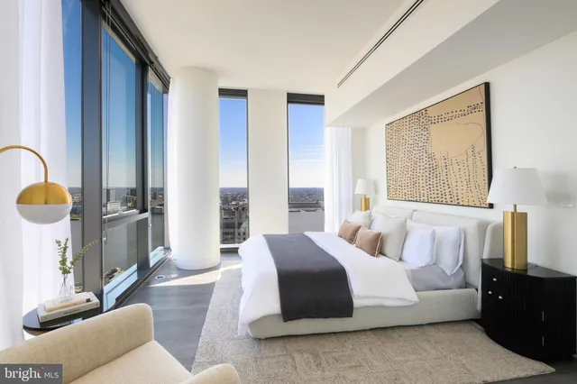 a spacious bedroom with a bed a couch and dresser