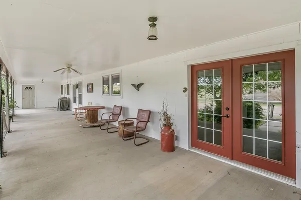 a living room with furniture gym equipment and large windows